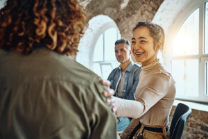 an alcohol addiction rehab participant welcomes a new member to group therapy 