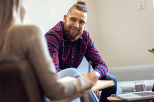 a man with a beard smiles at another member in his fentanyl addiction rehab program