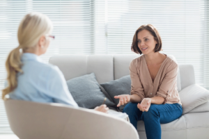 patient sits on a couch and faces her therapist and talks