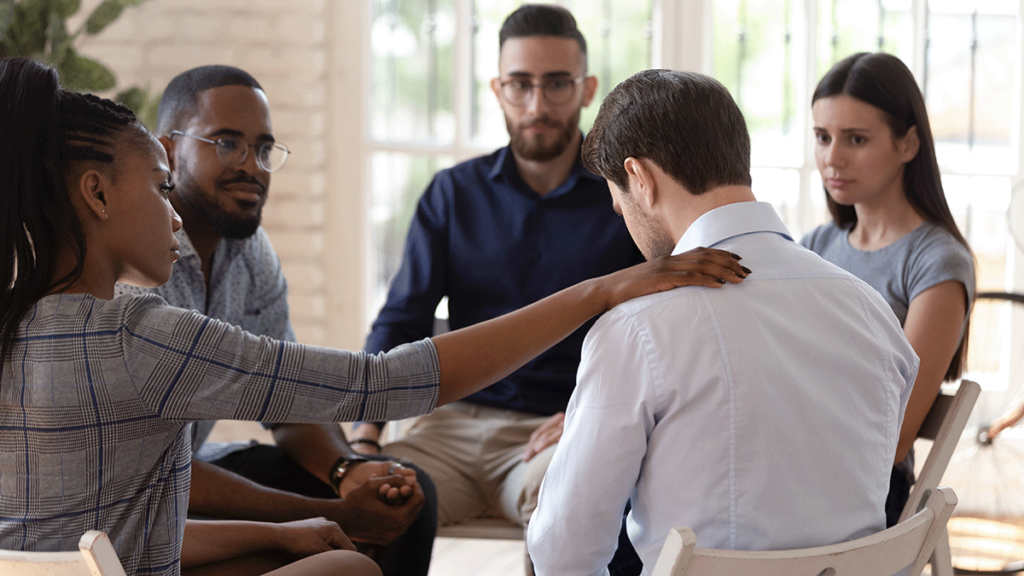 in a group therapy session a woman consoles another member after they discuss the benefits of cocaine addiction treatment