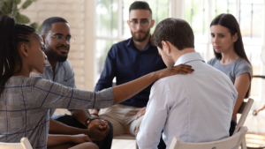 in a group therapy session a woman consoles another member after they discuss the benefits of cocaine addiction treatment